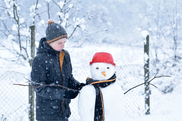 Niño haciendo un muñeco de nieve, divertidas actividades de invierno