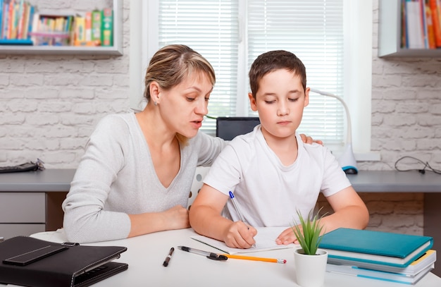 Niño haciendo la tarea en casa con libros. Educación, educación en casa