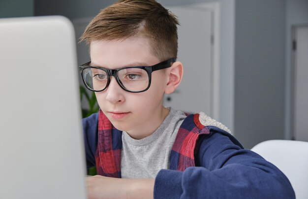 Niño haciendo la tarea en la computadora portátil