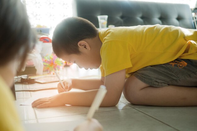 niño haciendo la tarea niño escribiendo papel educación concepto regreso a la escuela