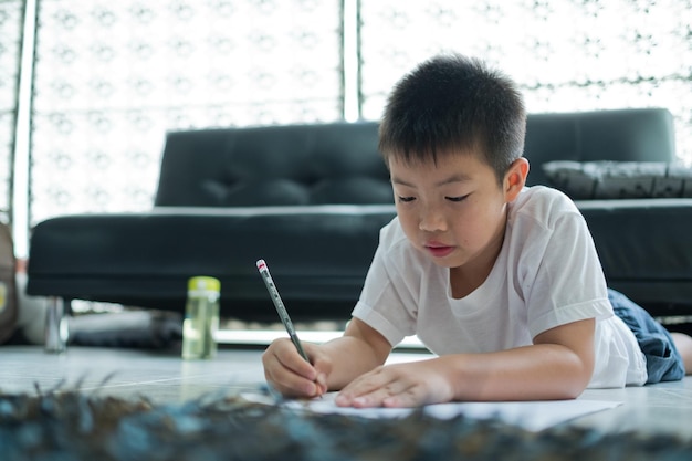 niño haciendo la tarea niño escribiendo papel educación concepto regreso a la escuela