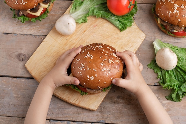 Niño con hamburguesa de champiñones a la parrilla