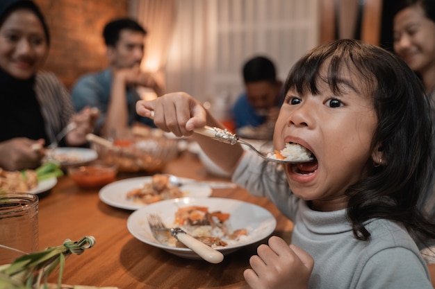 Niño hija comiendo sola durante la cena