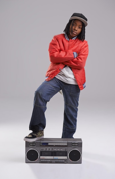 Niño hip hop y retrato cool con radio para música y rap en un estudio con ropa urbana Niño africano de moda y boombox con ropa de moda y botín juvenil con confianza y fondo gris