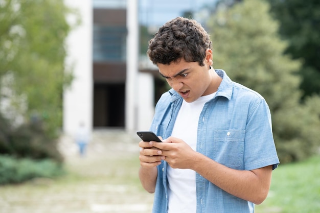 Niño hispano decepcionado mirando el teléfono