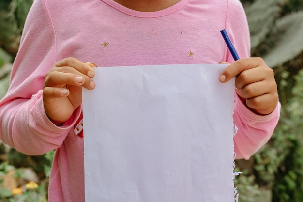 Niño con hoja en blanco para un mensaje importante para la sociedad.