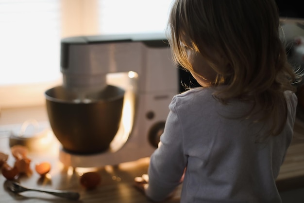 Niño horneando pastel en una acogedora cocina en casa