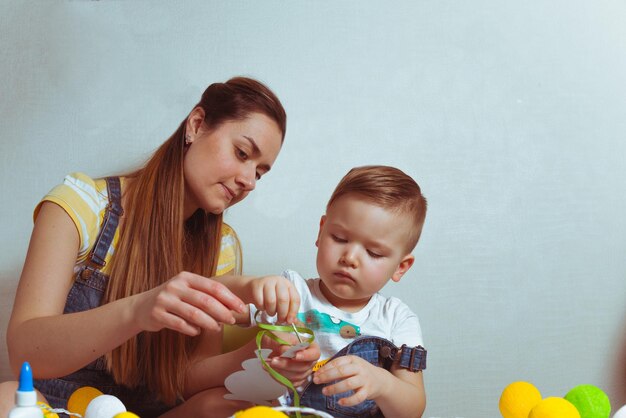 Niño con huevos de color madre para pascua.