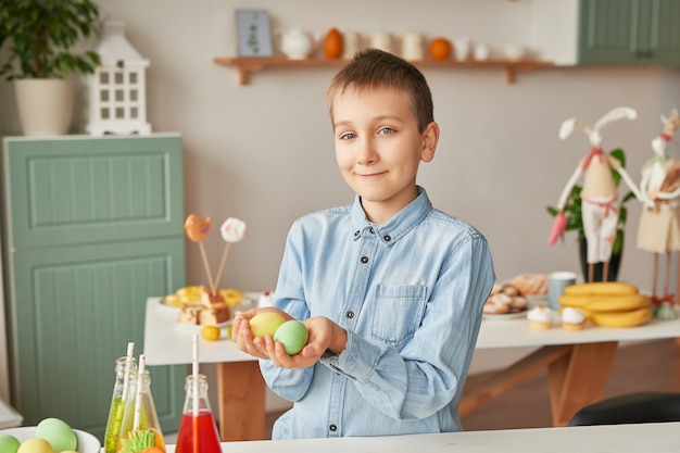 Niño con huevos de Pascua en la cocina