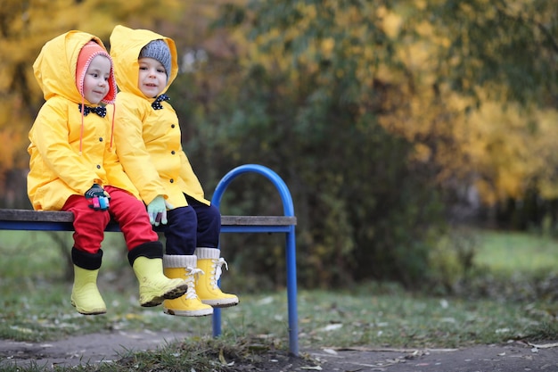 Un niño con un impermeable para caminar al aire libre en el día de otoño