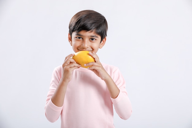 Niño indio / asiático comiendo mango