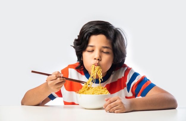 Niño indio comiendo deliciosos fideos