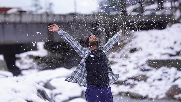 Niño indio disfrutando y jugando con la nieve durante las nevadas de invierno