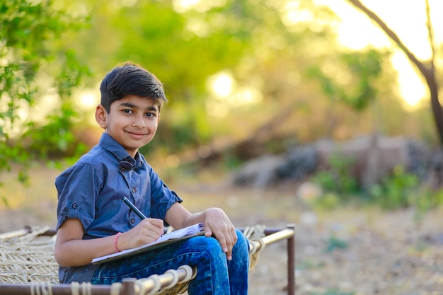 Niño indio escribiendo en cuaderno