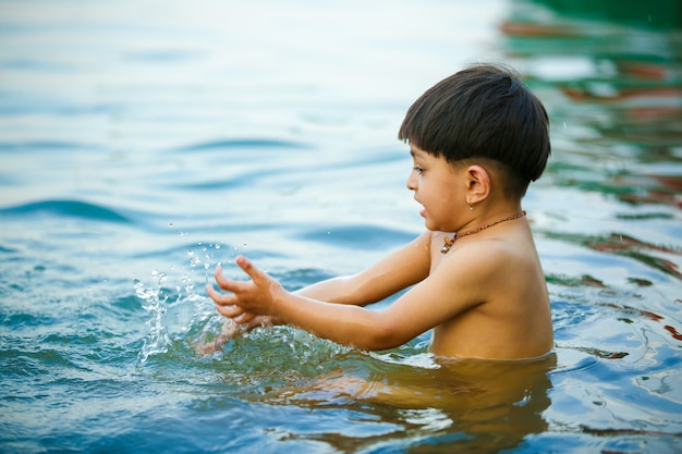 Niño indio jugando en el agua