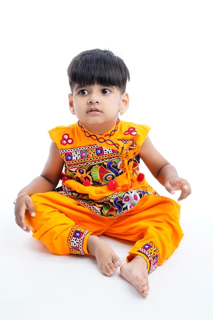 Niño indio mostrando trajes tradicionales indios usados durante el festival hindú de Navratri en el estado de Gujarat India blanco aislado