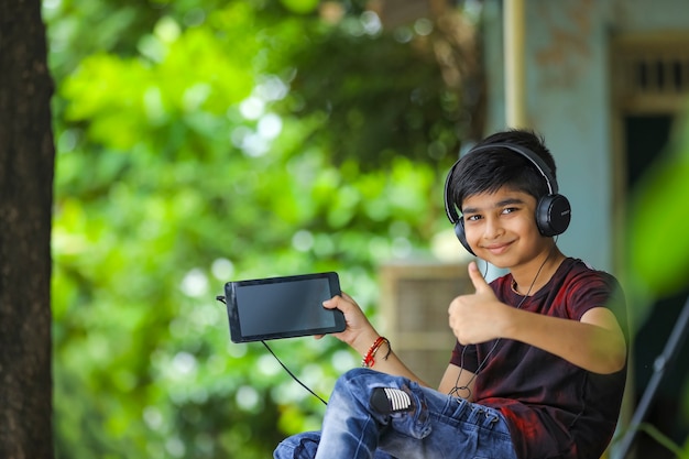 Niño indio que muestra la pantalla del teléfono inteligente