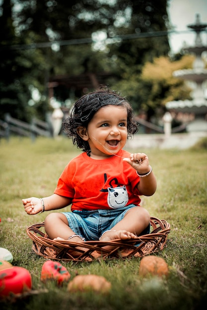 Niño indio con ropa tradicional en el parque Anbd Cute Boy And Green Garden