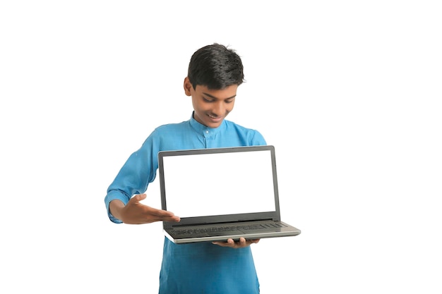Niño indio vistiendo ropa tradicional y mostrando la pantalla del portátil