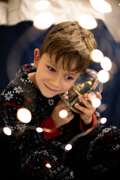 Niño de la infancia de Navidad sueña con linternas de vacaciones de árbol de Navidad de noche