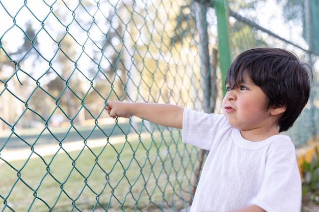 Niño inocente mexicano jugando en la valla