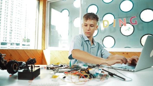 Niño inspecciona o aprende a usar herramientas electrónicas para arreglar el modelo de automóvil