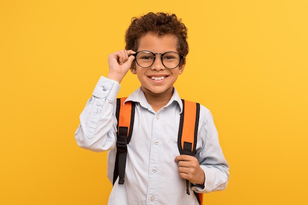 Foto niño inteligente con gafas camisa blanca mochila
