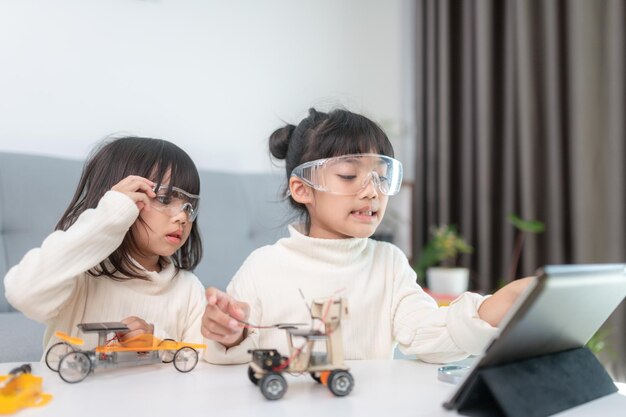 Niño inventivo construyendo coches robot en casa.