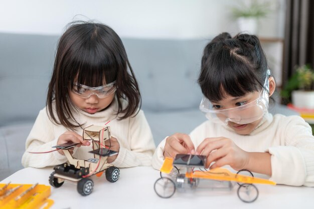 Niño inventivo construyendo coches robot en casa.