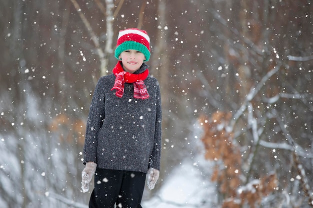 Niño en invierno en el bosque Un niño pequeño un niño con ropa de invierno caminando bajo la nieve