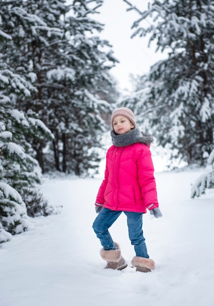 Niño en invierno. Una niña, jugando afuera en el invierno. Un hermoso retrato de niño de invierno. Niño feliz, diversión de invierno al aire libre.