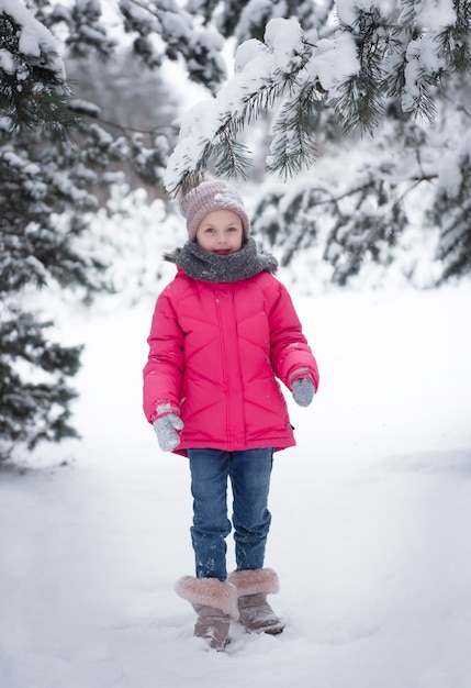 Niño en invierno. Una niña, jugando afuera en el invierno. Un hermoso retrato de niño de invierno. Niño feliz, diversión de invierno al aire libre.