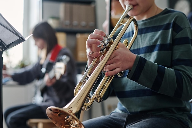 Un niño irreconocible tocando la trompeta