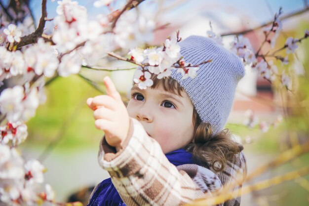 Un niño en un jardín florido. Enfoque selectivo