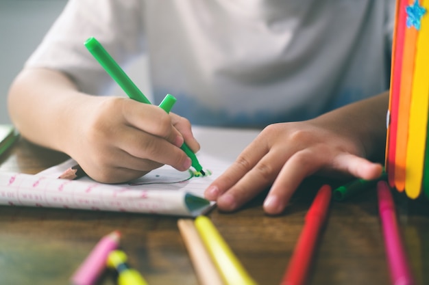 Niño de jardín de infantes dibujando y aprendiendo en casa. Educación, concepto de aprendizaje a distancia.