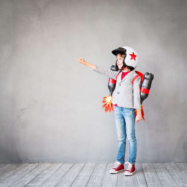 Niño con jet pack. Niño jugando en casa. Concepto de tecnología de éxito, imaginación e innovación.