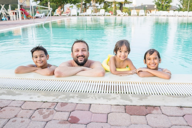 Niño joven niño niño splashing en la piscina que tiene diversión actividad de ocio