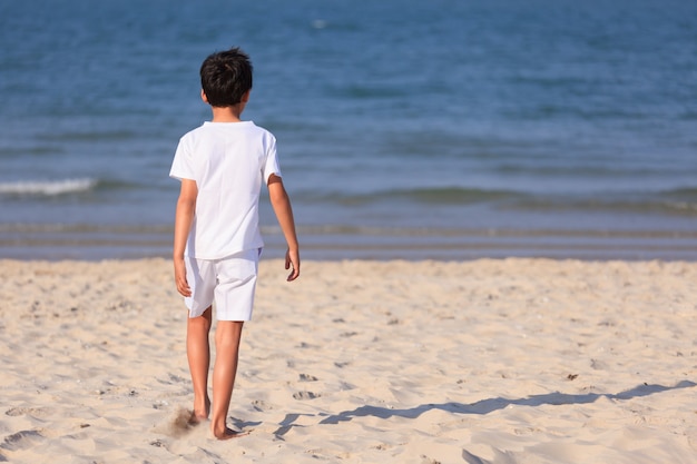 Niño joven, en, tela blanca, en, playa