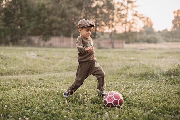 Foto un niño juega al fútbol en el campo la infancia alegre del bebé deportes activos