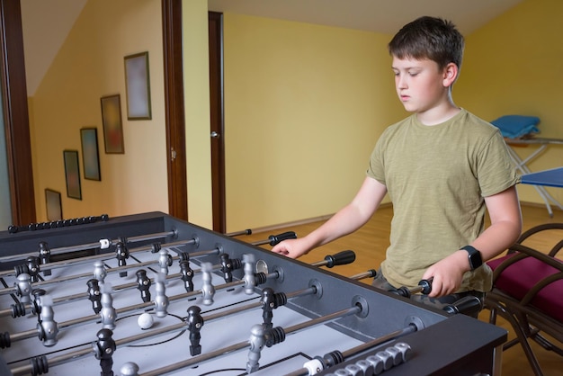 Foto un niño juega al futbolín concepto deportivo