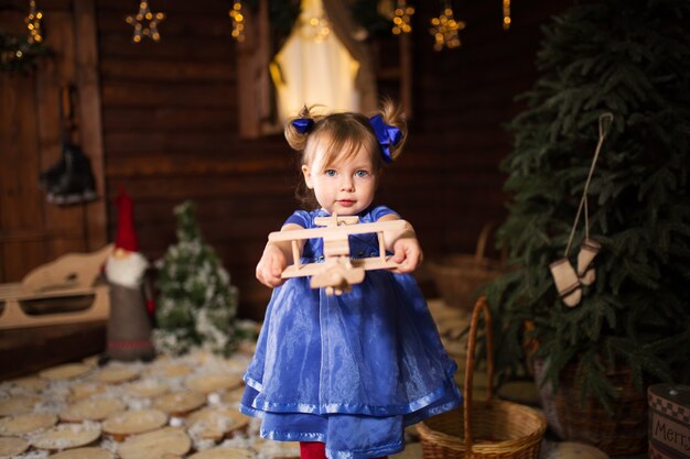 Un niño juega con un avión de madera que Santa le regaló por Navidad.