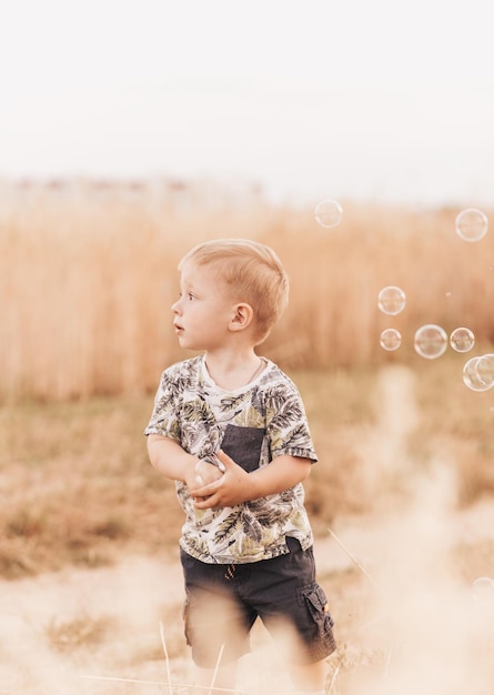 Niño juega y camina en la naturaleza en el verano Infancia feliz Emociones positivas