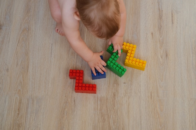 El niño juega constructor colorido. El niño recoge los números 2022. Concepto - juguetes de los niños y la infancia.