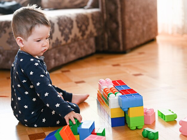 Un niño juega con un constructor multicolor.