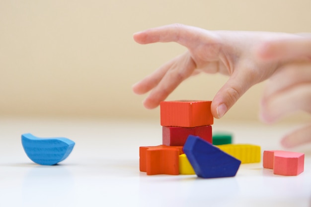 El niño juega con figuras de colores. Detalles del juguete en las manos.