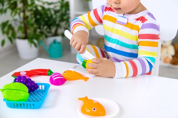 Niño juega juguetes de cocina y comida Enfoque selectivo