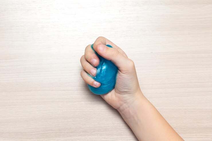 Foto un niño juega con una mano de baba azul un juguete transparente antiestrés