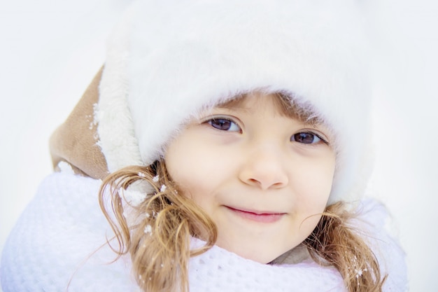 Un niño juega en la nieve en el invierno. Enfoque selectivo