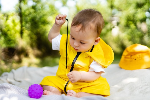 Niño juega con pequeños juguetes en el césped Baby boy al aire libre en el césped Baby boy explorando la naturaleza