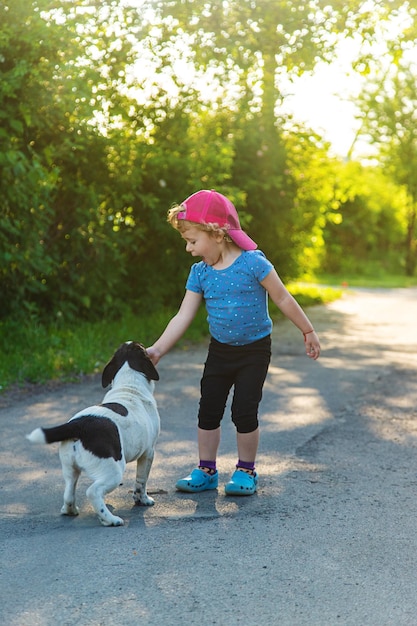 Un niño juega con un perro pequeño en el parque Enfoque selectivo